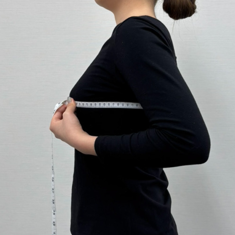 横向きでトップバストの測定を行っている女性のイメージ写真